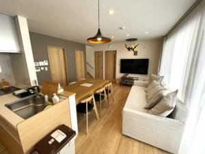 a kitchen and living room with a table and a couch at Niseko STREAM Villas in Rankoshi