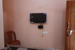 a flat screen tv hanging on a wall at Wisma Gokilambal Residency in Tiruvannāmalai