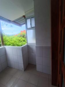 baño con paredes de azulejos blancos y ventana en Galapagos Verde Azul, en Puerto Ayora