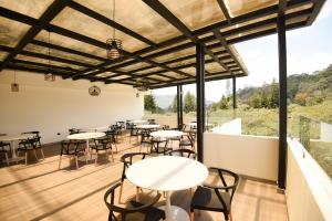 uma sala de jantar com mesas, cadeiras e janelas em Elithe Hotel em La Esperanza