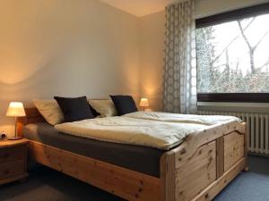 Schlafzimmer mit einem großen Holzbett und einem Fenster in der Unterkunft Ferienhaus Küstille in Medebach