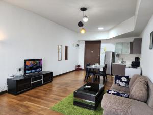 Il comprend un salon doté d'un canapé et d'une télévision. dans l'établissement Regalia Serviced Suites KLCC Infinitypool, à Kuala Lumpur