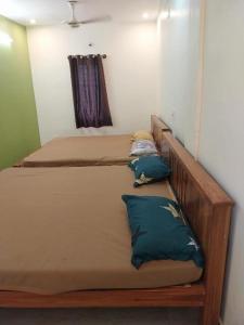 two beds in a room with two pillows at New greens inn in Yelagiri