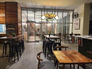 a restaurant with wooden tables and chairs and windows at Regalia Serviced Suites KLCC Infinitypool in Kuala Lumpur