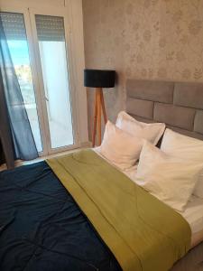 a bed sitting in a room with a window at Appart Cozy in Le Bardo
