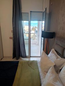 a bedroom with a bed and a door to a balcony at Appart Cozy in Le Bardo