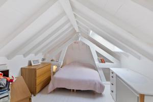 a bedroom with a bed in the attic at Grande villa 20 min de Paris centre in Garches