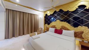 1 dormitorio con 1 cama grande y cabecero dorado en HOTEL VIJAYARANI, en Tiruchchirāppalli