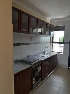 a kitchen with a sink and a stove top oven at VILLA FIORI APARTMENTS in Arua