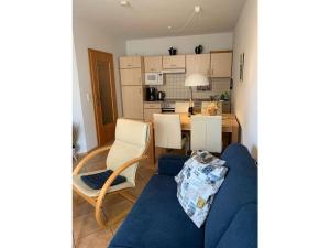 a living room with a blue couch and a kitchen at Wood in Zempin Usedom in Zempin