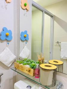 a bathroom with a mirror and a tray of greens at Holiday Escape Philippines in Manila