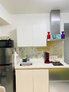 a kitchen with a sink and a refrigerator at Holiday Escape Philippines in Manila