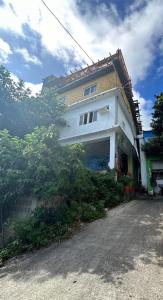 Biały dom z mnóstwem drzew przed nim w obiekcie A-Lang Homestay w mieście Lanyu