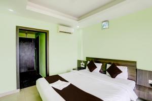 Schlafzimmer mit einem großen weißen Bett mit einem Kopfteil aus Holz in der Unterkunft Hotel Deep Ganga Inn Puri Sea View Room in Puri