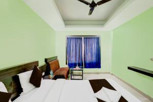 Schlafzimmer mit einem Bett und einem Fenster in der Unterkunft Hotel Deep Ganga Inn Puri Sea View Room in Puri