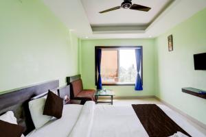 ein Hotelzimmer mit einem Bett und einem Fenster in der Unterkunft Hotel Deep Ganga Inn Puri Sea View Room in Puri