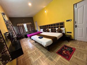 a bedroom with a large bed and a couch at The Black Magic Cottage in Ooty