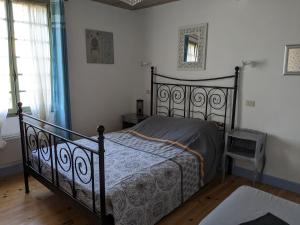 um quarto com uma cama preta num quarto em Le Clos des oliviers em Rieux-en-Val