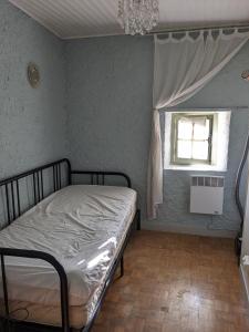 um quarto com uma cama e uma janela em Le Clos des oliviers em Rieux-en-Val