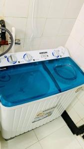 y baño con lavadora y blusa azul. en Mikocheni Full House - 1 Bedroom en Dar es Salaam