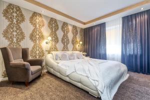 1 dormitorio con 1 cama y 1 silla en Jekaba Rezidence en Jelgava