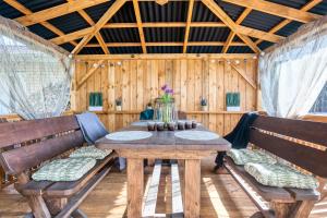 une salle à manger avec une table et des bancs en bois dans l'établissement Jekaba Rezidence, à Jelgava