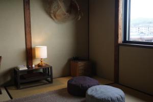 a corner of a room with a lamp and a window at 三間屋 mitsumaya in Kanazawa