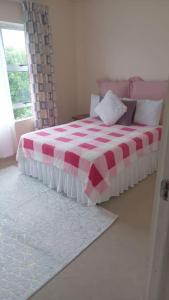 1 dormitorio con 1 cama con manta roja y blanca en 3/45 Oxley Road, en Port Edward