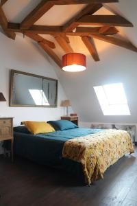 a bedroom with a bed with a blue comforter at Les Jardins des Soussilanges in Céron