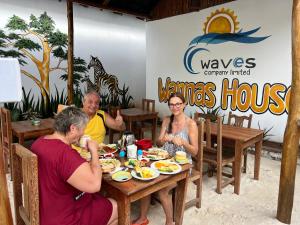 wannas house في نونغوي: مجموعة من الناس يجلسون على طاولة يأكلون الطعام