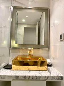 a bathroom with a gold sink and a mirror at CĂN HỘ 2 PN KHÁCH SẠN GOLDENBAY DÁT VÀNG in Da Nang
