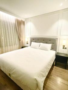a bedroom with a large white bed with two pillows at CĂN HỘ 2 PN KHÁCH SẠN GOLDENBAY DÁT VÀNG in Da Nang
