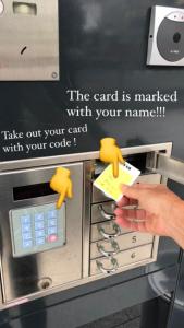 una persona con una tarjeta en una máquina de cajero automático en Hotel Plainbrücke | self check-in, en Salzburgo