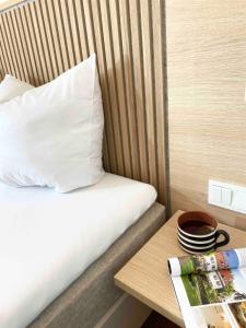 ein Bett mit einem weißen Kissen und einem Holztisch in der Unterkunft Hotel Zur Traube in Ürzig