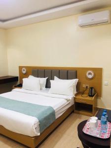 a bedroom with a large bed and a table at Fashion International Hotel in Dar es Salaam