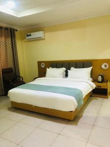 a bedroom with a large bed with a blue blanket at Fashion International Hotel in Dar es Salaam