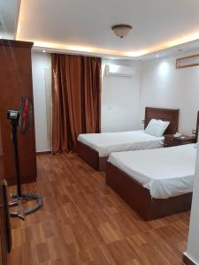 une chambre d'hôtel avec 2 lits et un appareil photo dans l'établissement السكن الفاخر, au Caire