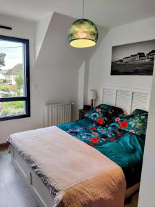 - une chambre avec un lit et une grande fenêtre dans l'établissement RARE à Cabourg - Maison neuve avec piscine et jardin, à Cabourg