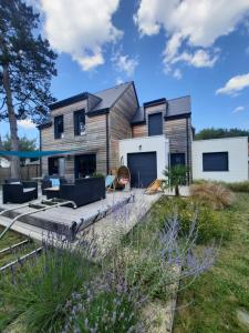 ein Haus mit einer Terrasse davor in der Unterkunft RARE à Cabourg - Maison neuve avec piscine et jardin in Cabourg