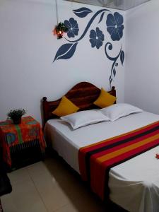 a bedroom with a bed with a flower mural on the wall at Near The Canal Homstay in Sigiriya