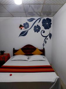 1 dormitorio con 1 cama con un mural de flores en la pared en Near The Canal Homstay en Sigiriya