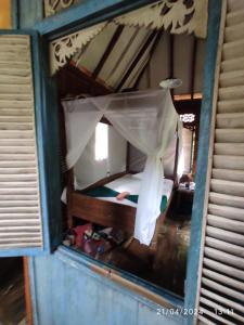 ein kleines Zimmer mit einem Bett im Fenster in der Unterkunft Dune Alaya Ecolodge in Pemuteran