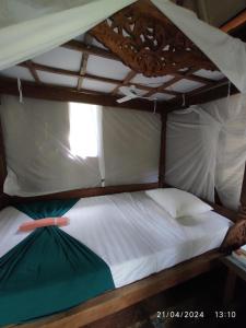 ein Etagenbett mit weißer Bettwäsche und einem Baldachin in der Unterkunft Dune Alaya Ecolodge in Pemuteran