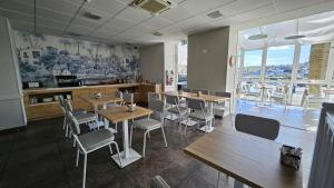 - un restaurant avec des tables et des chaises dans une salle dans l'établissement Le Benhuyc, à Binic