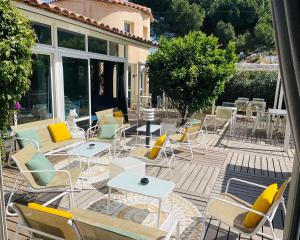 un grupo de sillas y mesas en un patio en Hotel & Spa Gil de France Cap d'Agde, en Cap d'Agde