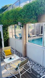 a patio with chairs and a table and a pool at Hotel & Spa Gil de France Cap d'Agde in Cap d'Agde