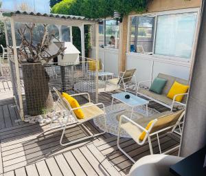a patio with chairs and a table and a couch at Hotel & Spa Gil de France Cap d'Agde in Cap d'Agde