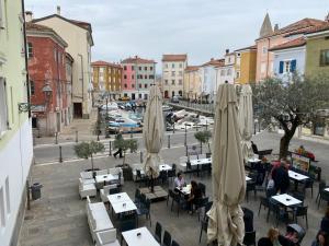 een restaurant met tafels en parasols in een stadsstraat bij Al FRONTE MARE SUITES APARTMENTS in Muggia