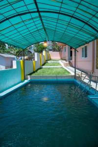 uma piscina de água com um dossel azul sobre ela em JK Resort em Yercaud