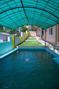 un bassin d'eau avec un auvent bleu au-dessus dans l'établissement JK Resort, à Yercaud